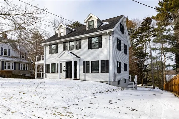 a front view of a house with a yard covered in snow