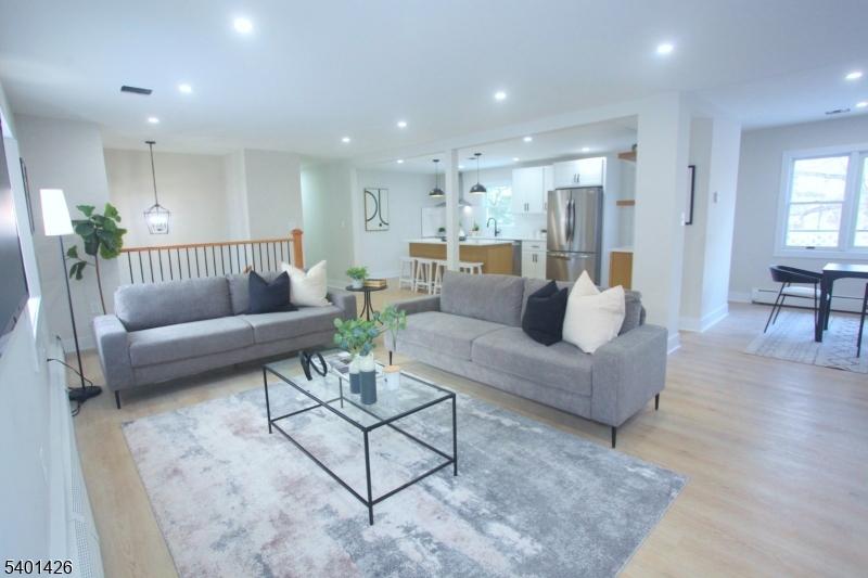 a living room with furniture and a view of kitchen