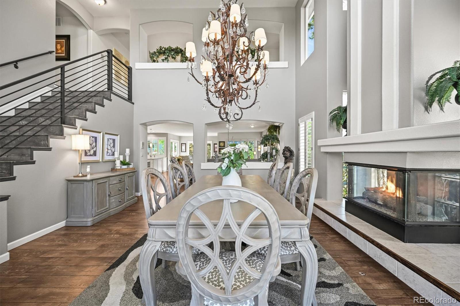 6242 Shea Place Highlands Ranch, CO 80130 - Photo 2 of 45 a view of a dining room with furniture a chandelier and wooden floor