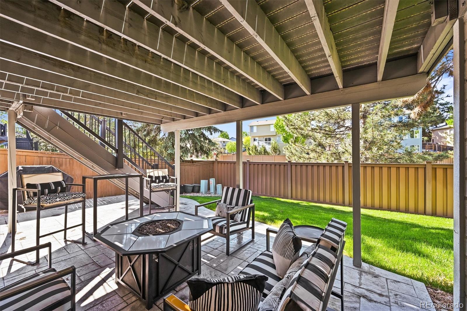 6242 Shea Place Highlands Ranch, CO 80130 - Photo 33 of 45 a view of a patio with table and chairs with wooden floor and fence