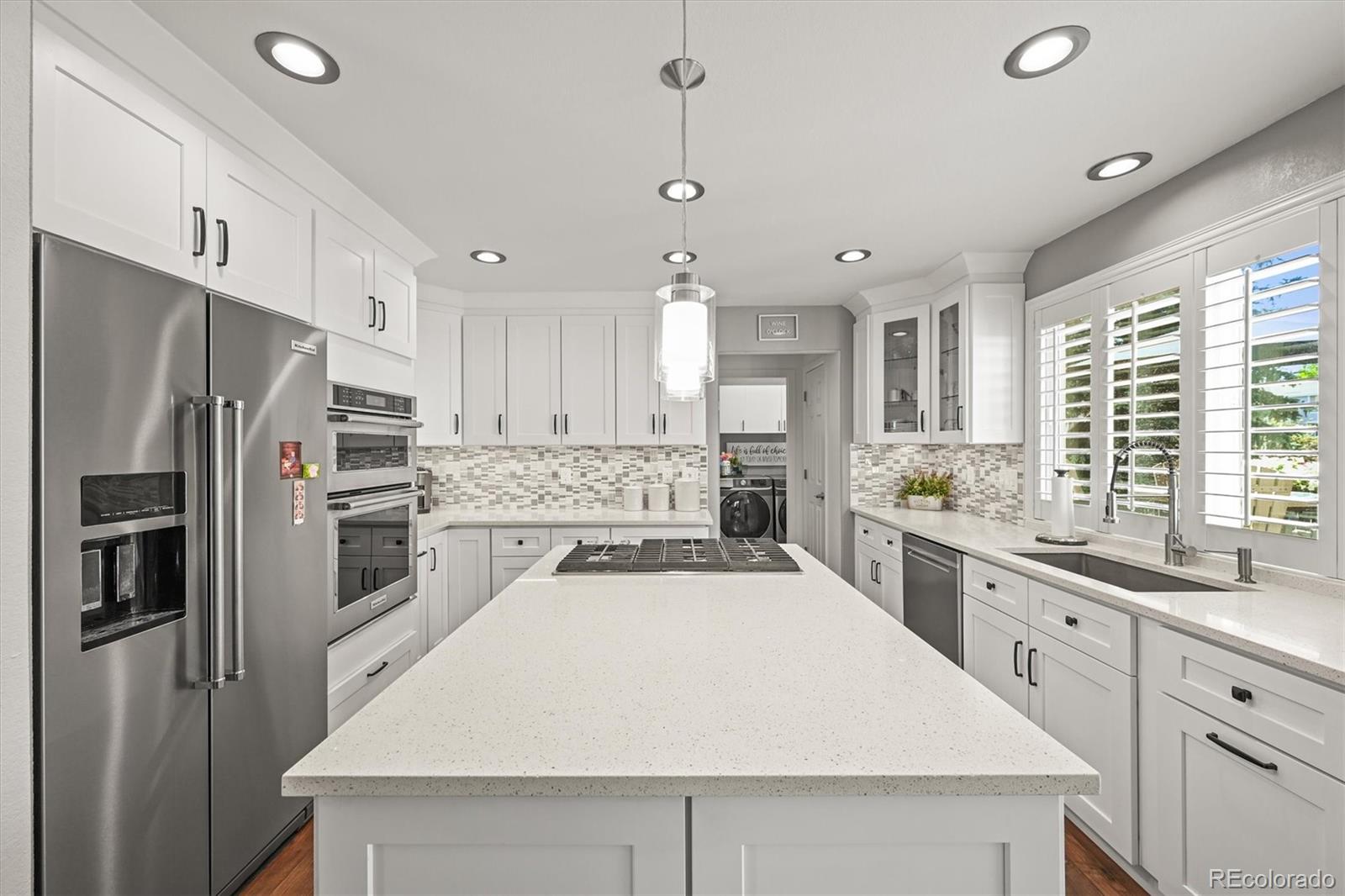 6242 Shea Place Highlands Ranch, CO 80130 - Photo 8 of 45 a large kitchen with kitchen island a sink stainless steel appliances and cabinets