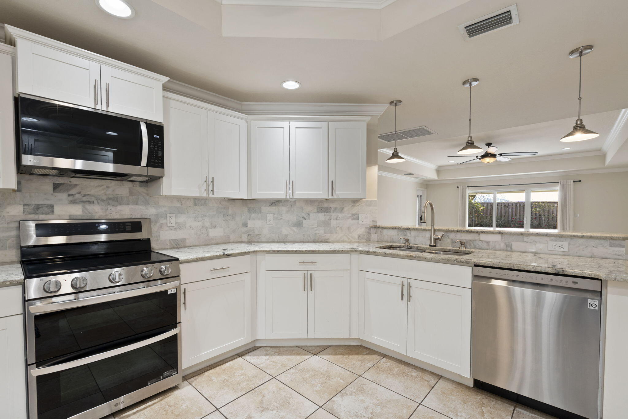 339 Southwest Winnachee Drive Stuart, FL 34994 - Photo 13 of 52 a kitchen with granite countertop white cabinets and stainless steel appliances