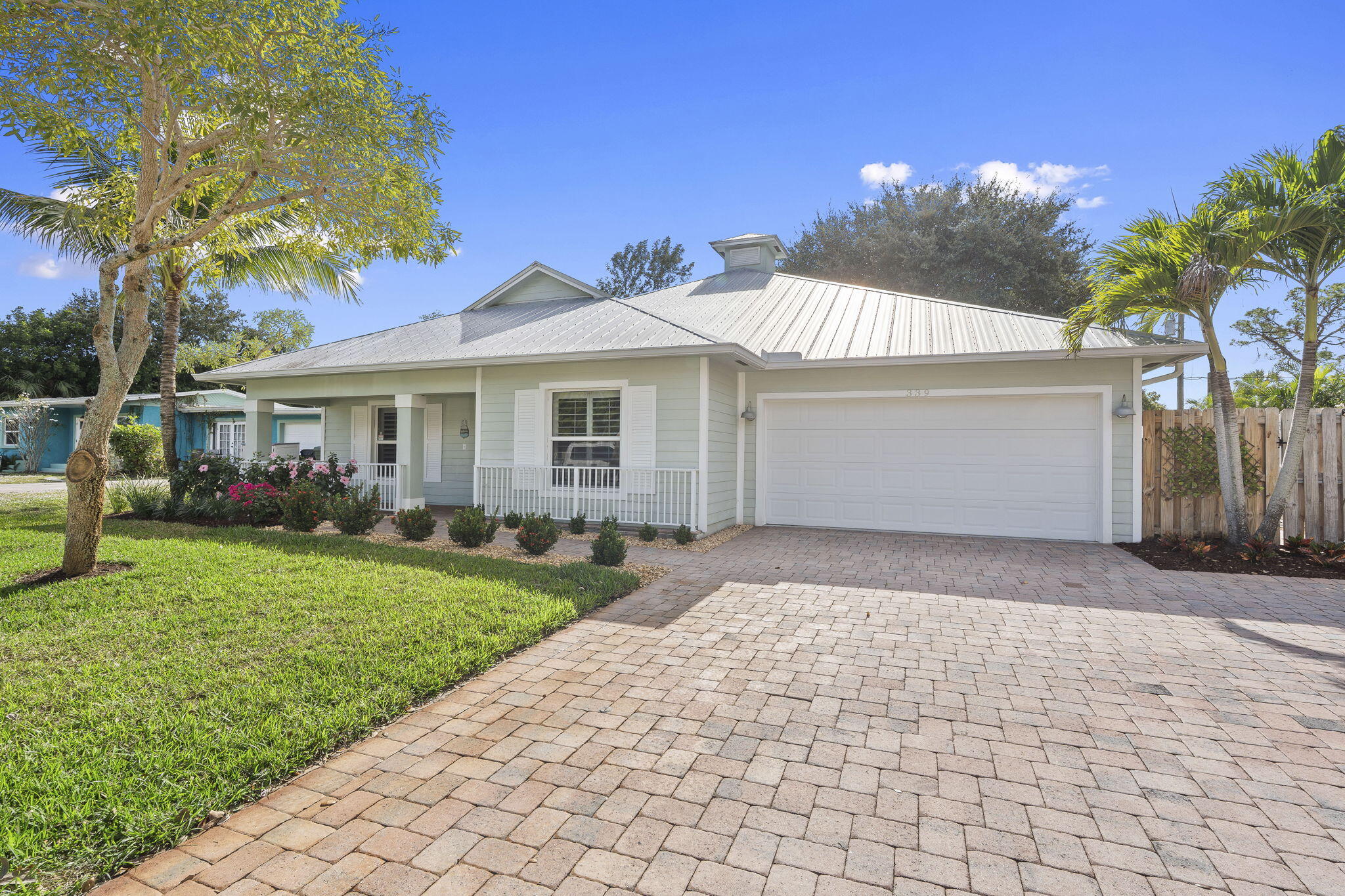339 Southwest Winnachee Drive Stuart, FL 34994 - Photo 2 of 52 a front view of a house with a garden and yard