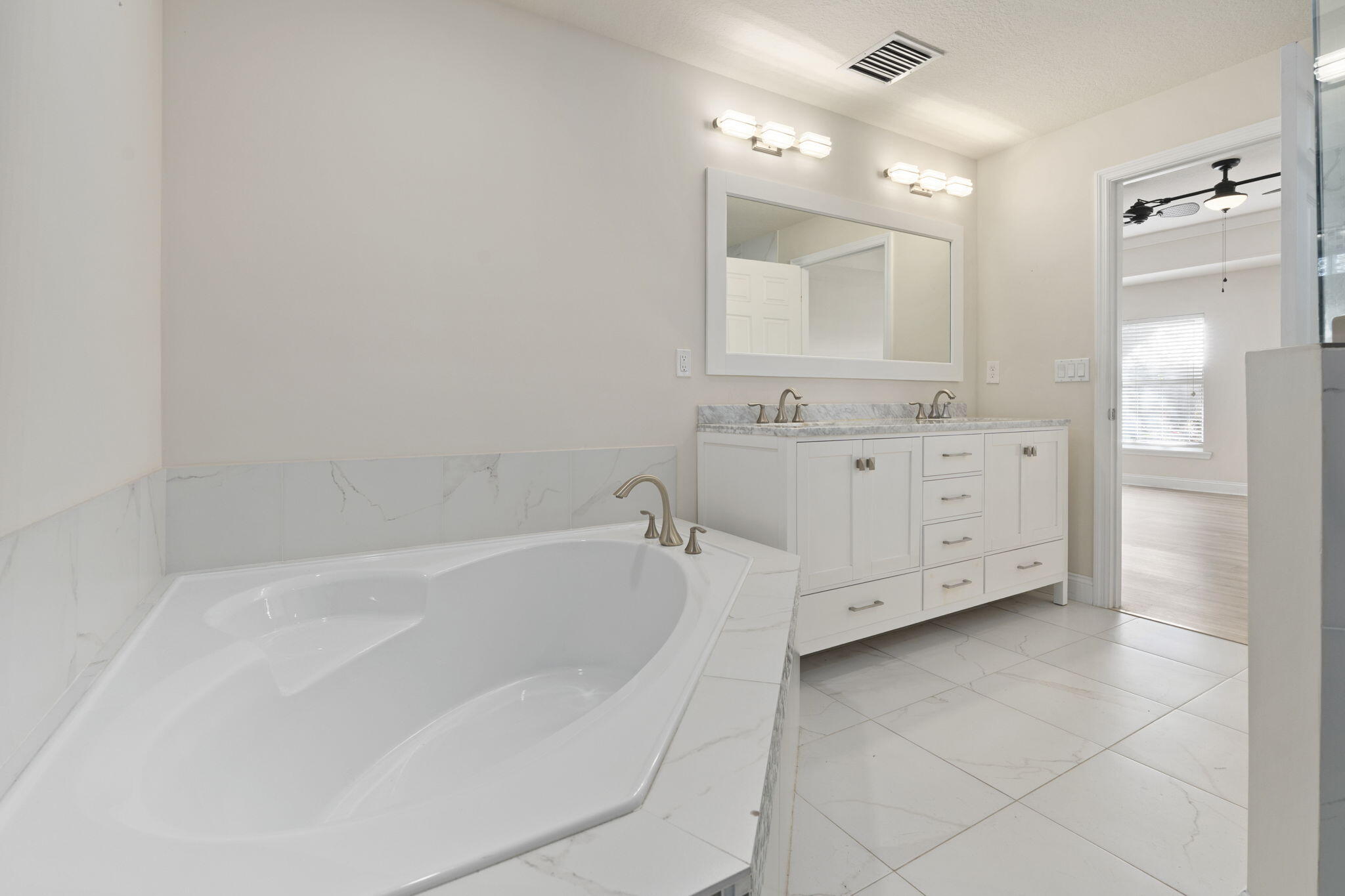 339 Southwest Winnachee Drive Stuart, FL 34994 - Photo 24 of 52 a bathroom with a bathtub a double vanity sink and mirror