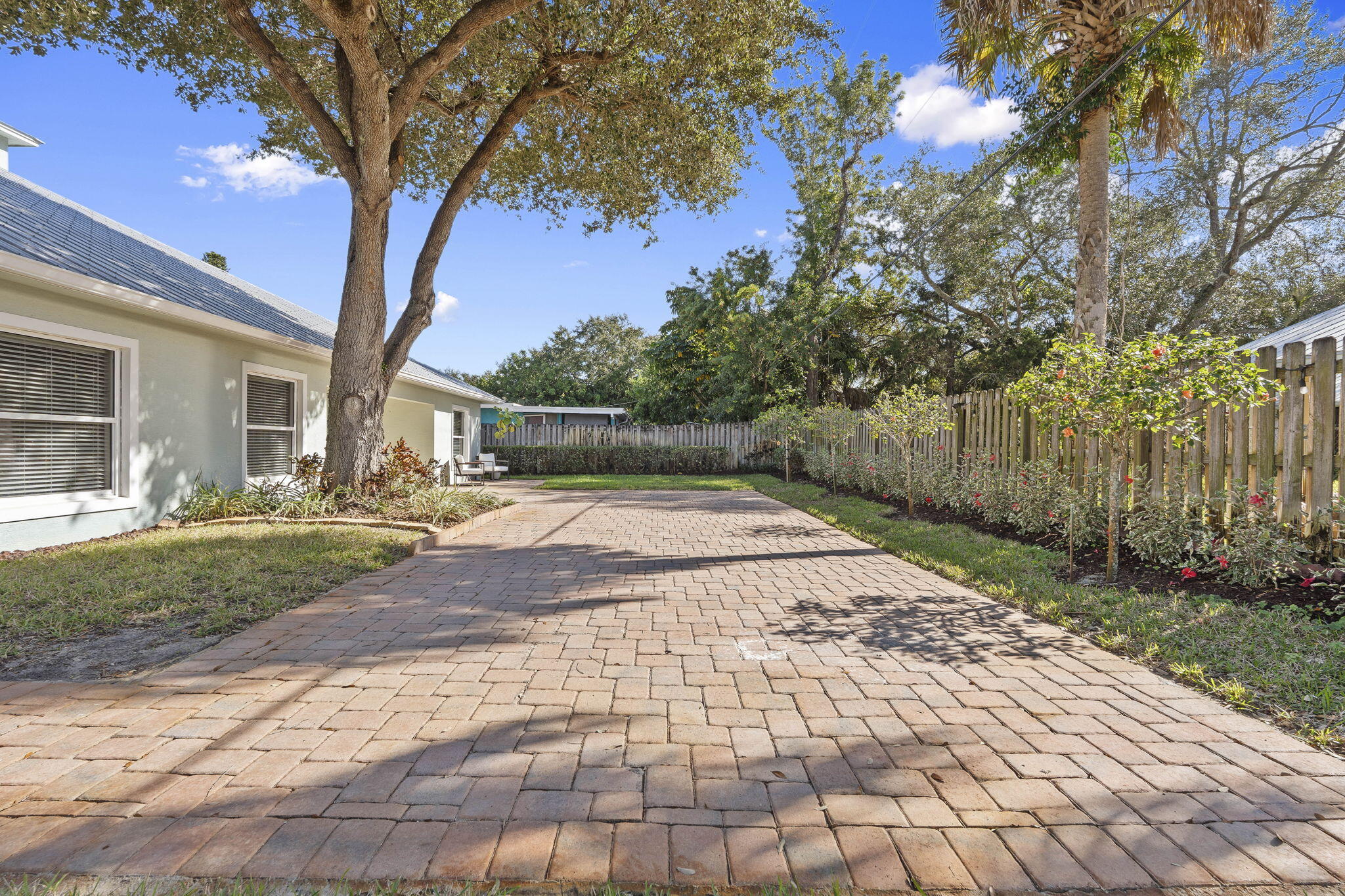 339 Southwest Winnachee Drive Stuart, FL 34994 - Photo 42 of 52 a view of a yard with plants and a large tree