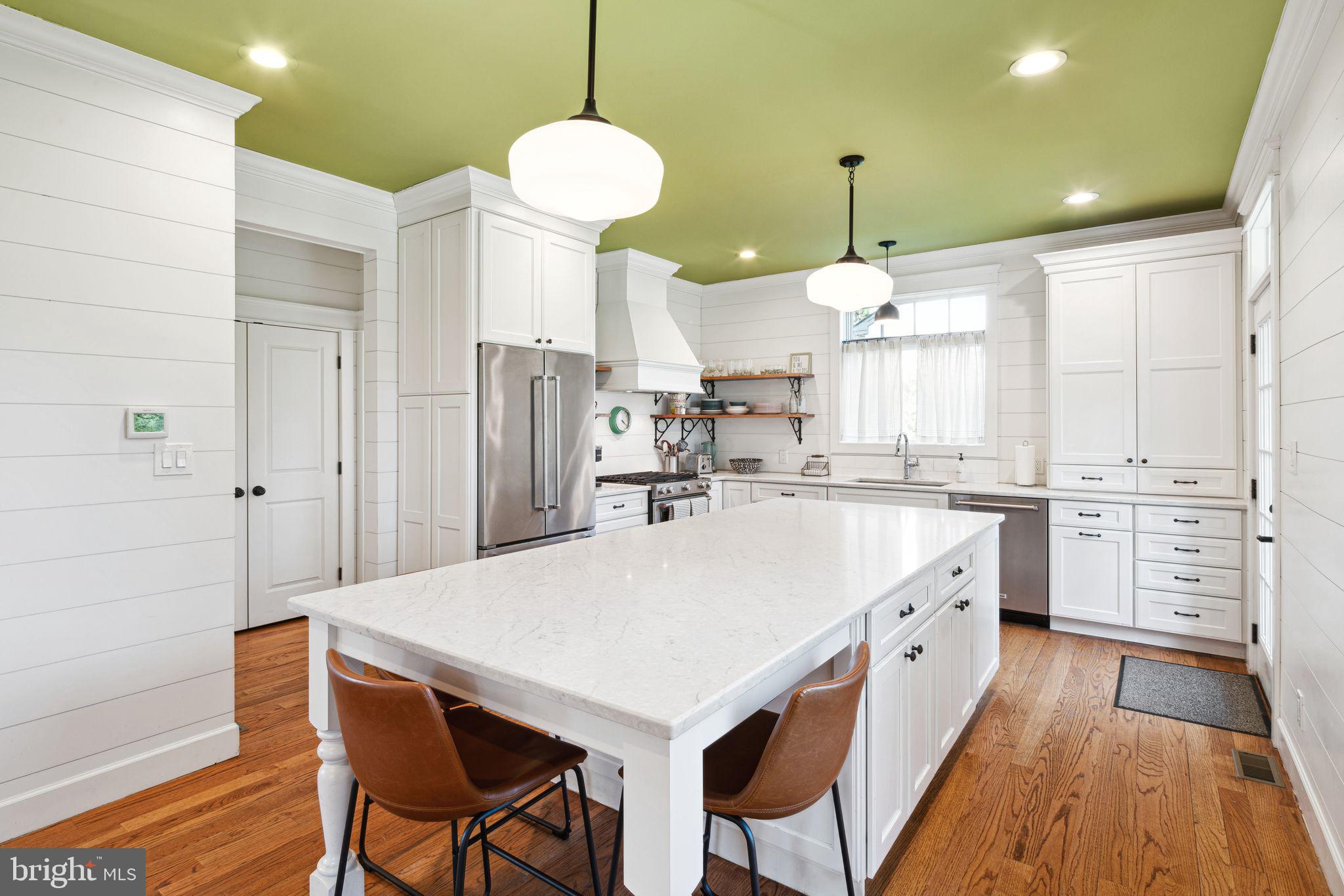 439 Crescent Road Wyncote, PA 19095 - Photo 11 of 31 a large kitchen with kitchen island a stove a sink a refrigerator and white cabinets with wooden floor