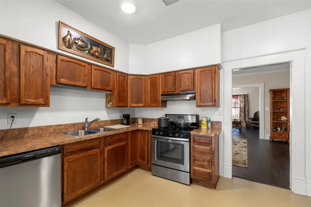 a kitchen with stainless steel appliances granite countertop a stove sink and cabinets