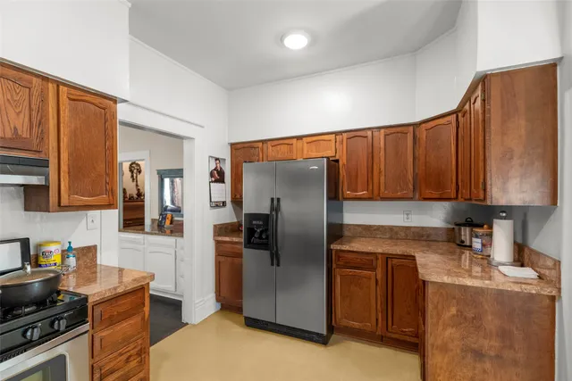 a kitchen with stainless steel appliances granite countertop a refrigerator stove and sink