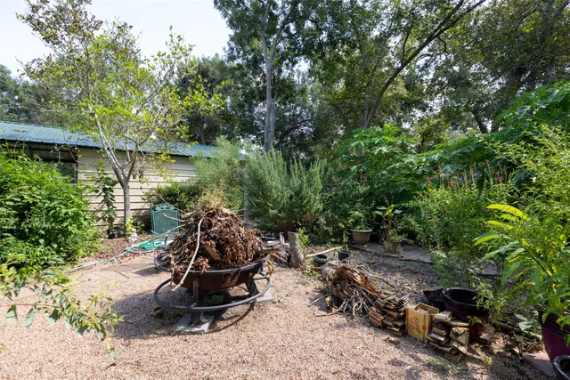 a view of a backyard with table and chairs and potted plants