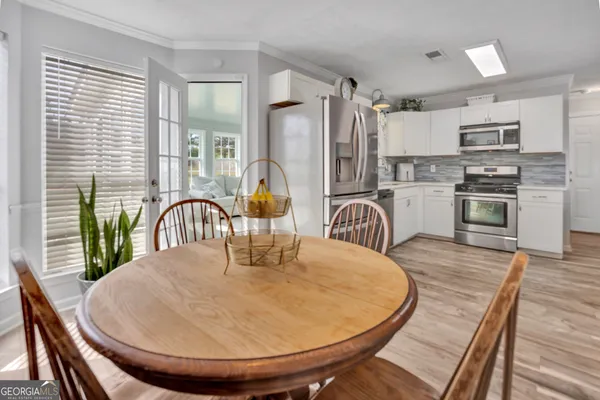 a dining room with furniture a window and kitchen view