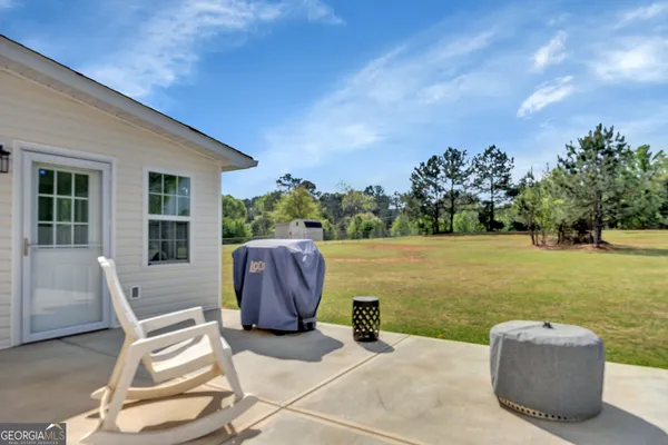 a view of a patio with a table and chairs next to a yard
