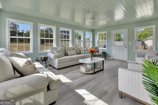 a living room with furniture and large windows