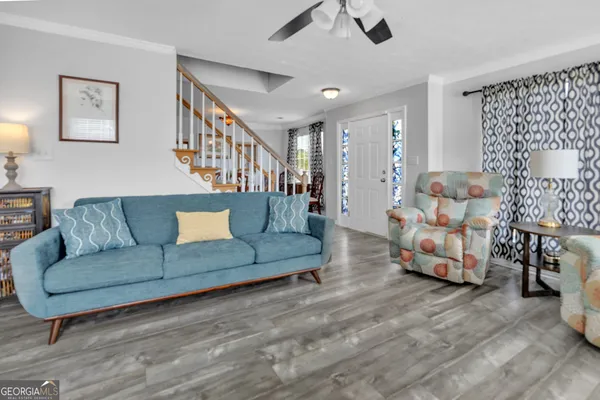 a living room with furniture and a wooden floor