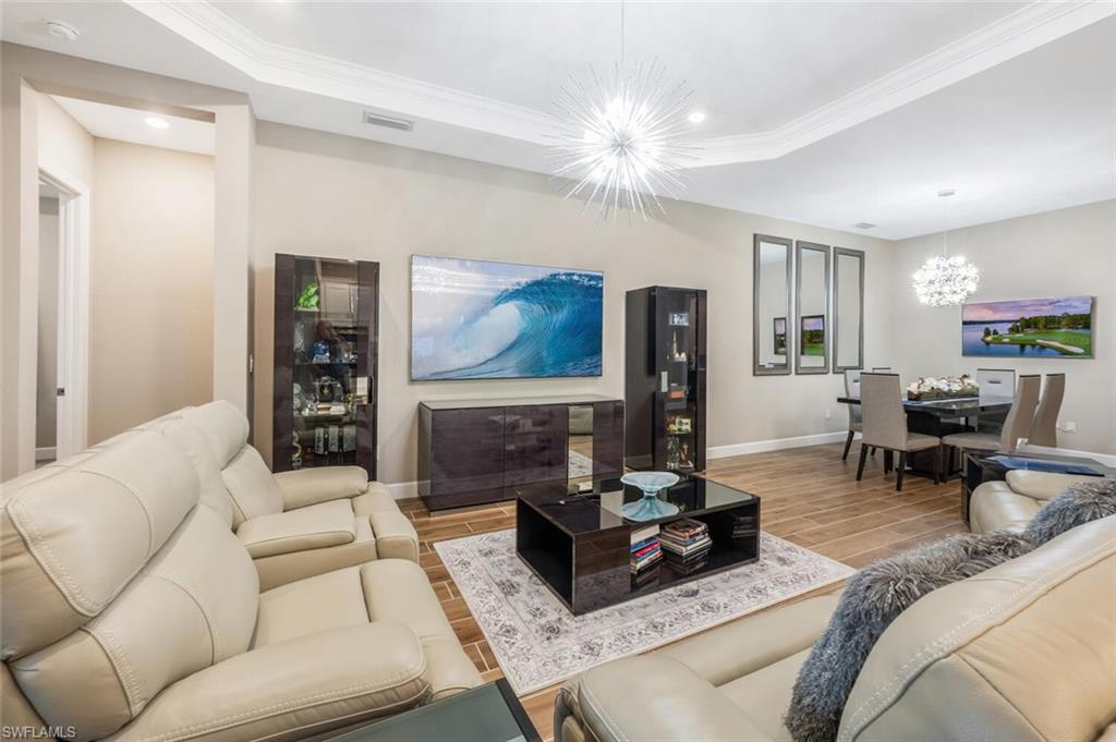 8416 Rosa Court Naples, FL 34114 - Photo 6 of 34 Open concept living area featuring wood-finish flooring, recessed lighting, and a tray ceiling with crown molding