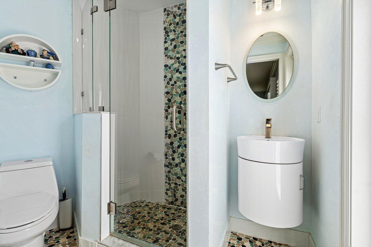 701 Buoy Road North Palm Beach, FL 33408 - Photo 26 of 52 a bathroom with a toilet a sink and mirror
