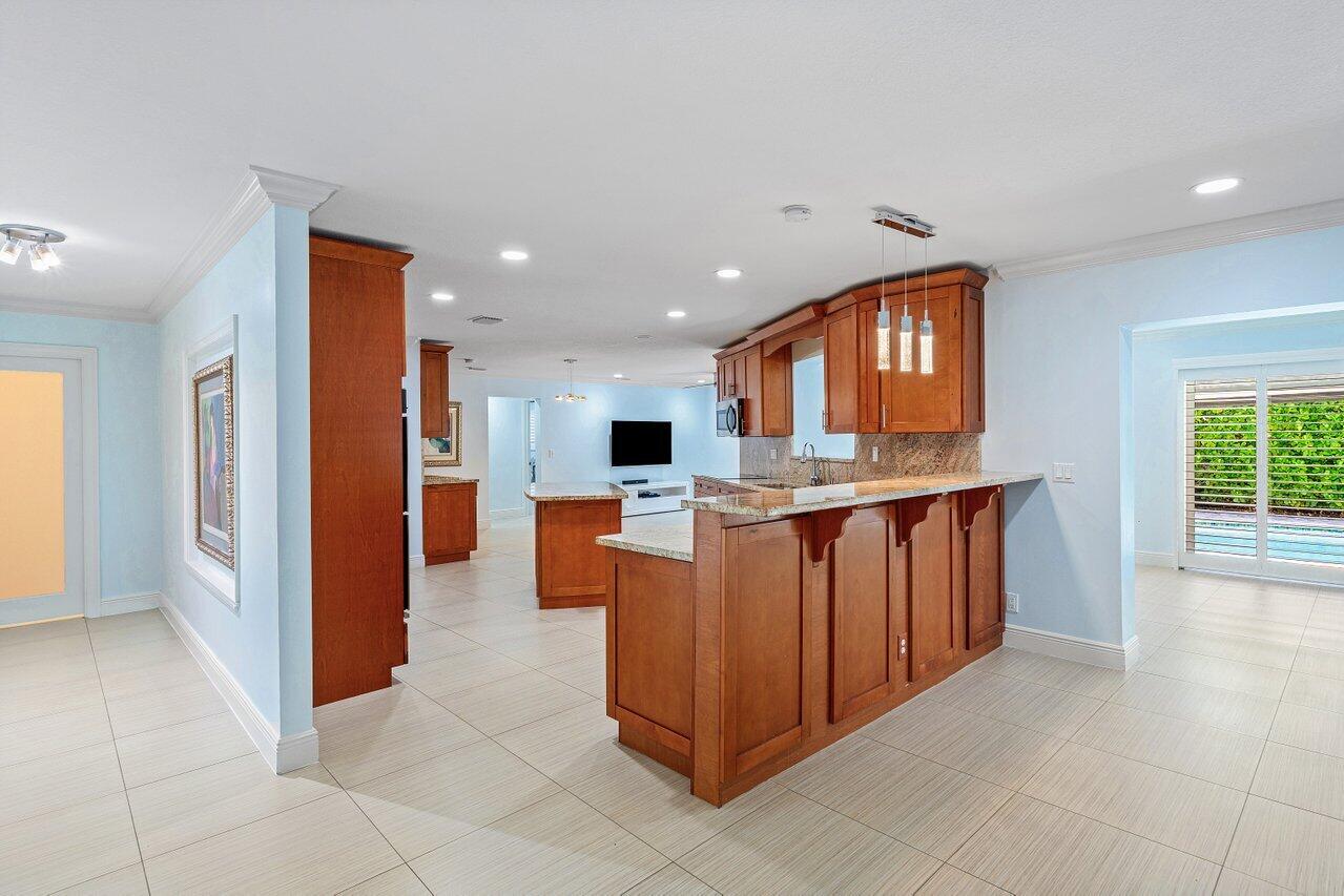 701 Buoy Road North Palm Beach, FL 33408 - Photo 8 of 52 a kitchen with stainless steel appliances granite countertop a refrigerator and a sink