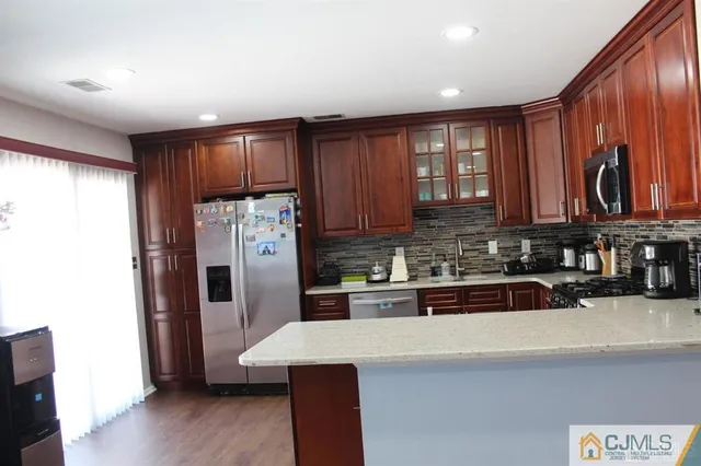 a kitchen with stainless steel appliances granite countertop a refrigerator sink and cabinets