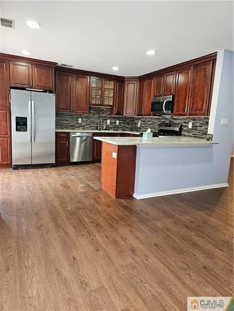a kitchen with stainless steel appliances granite countertop a refrigerator stove a sink and dishwasher