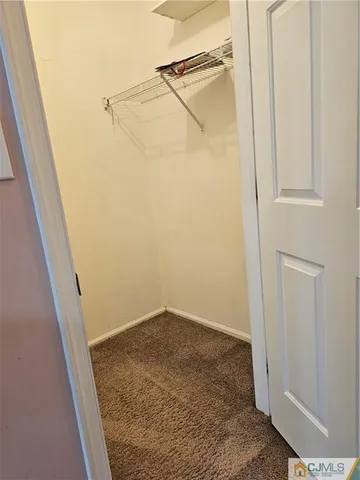 a view of a hallway with wooden floor and a cabinet