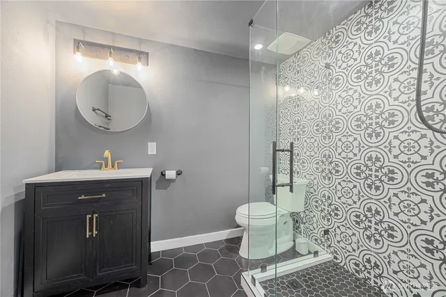 a bathroom with a toilet a sink and mirror