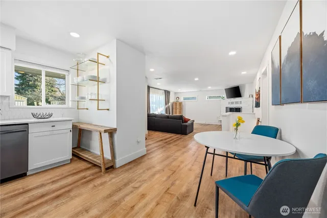 a kitchen with a table chairs a sink dishwasher stove and microwave with wooden floor