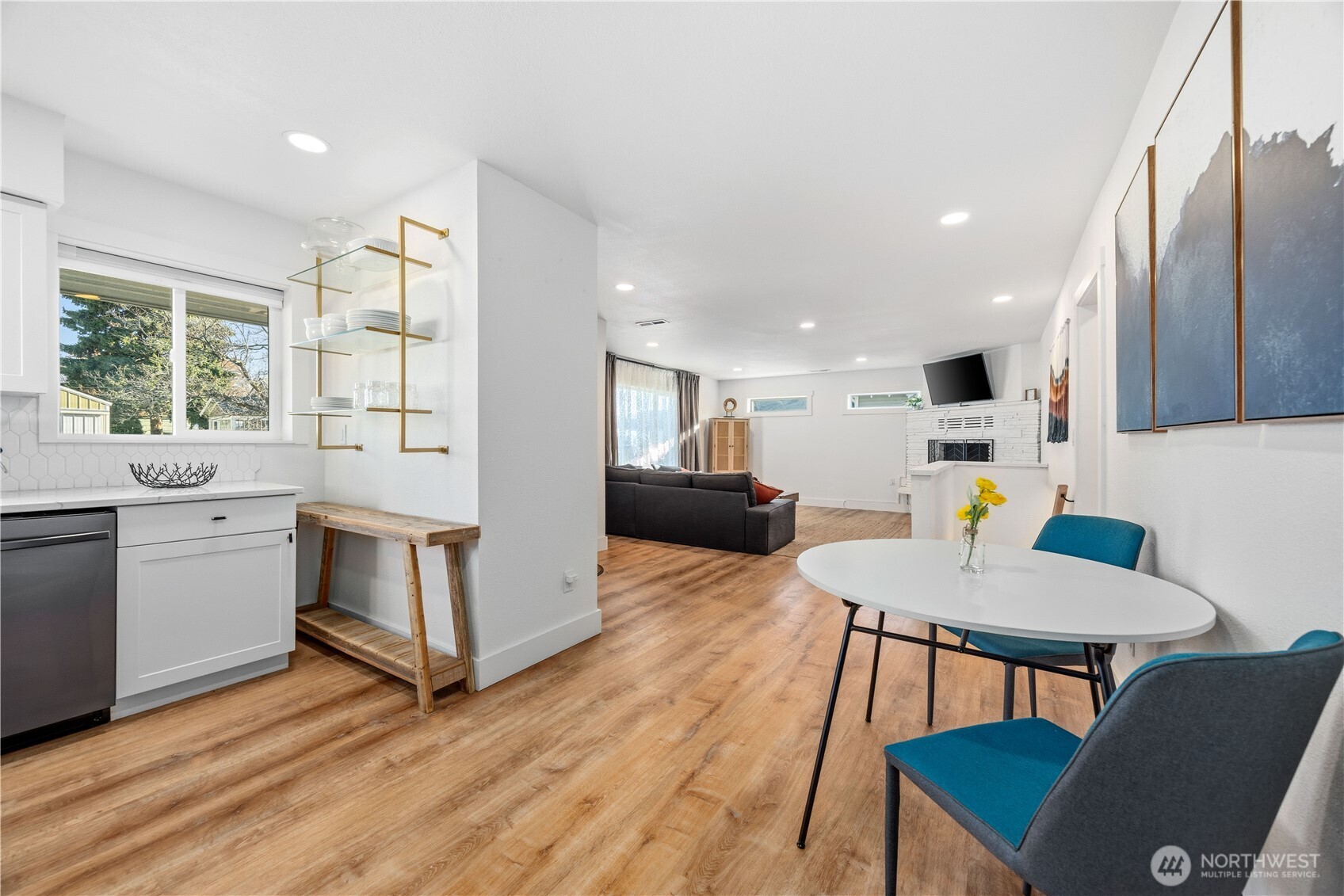 409 North Cedar Street Chelan, WA 98816 - Photo 9 of 33 a kitchen with a table chairs a sink dishwasher stove and microwave with wooden floor
