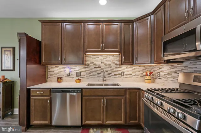 a kitchen with stainless steel appliances wooden cabinets and a stove top oven