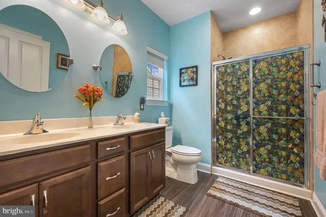 a spacious bathroom with a double vanity sink toilet and a mirror