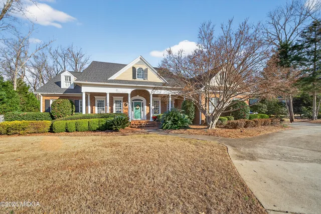 a front view of a house with a yard and trees