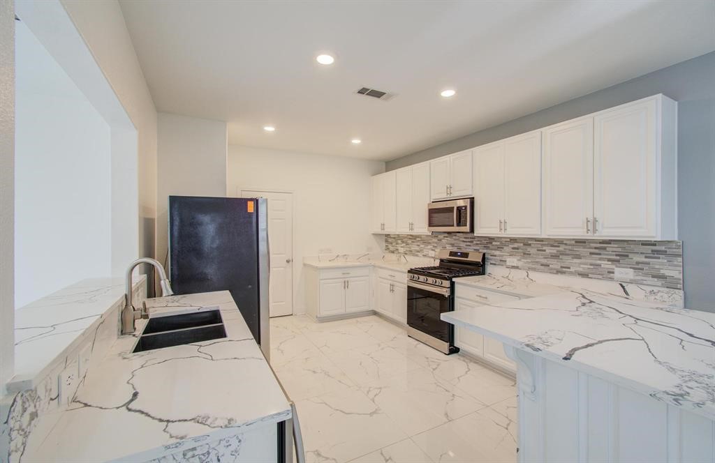 4627 Prairie Chase Drive Houston, TX 77069 - Photo 6 of 23 Kitchen — Stylish modern kitchen with contemporary cabinetry, quartz-style countertops, stainless-steel appliances, and upgraded fixtures. The clean design and open flow make it ideal for cooking, hosting, and everyday convenience.