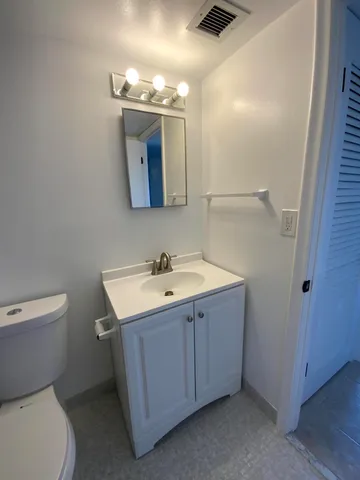 a bathroom with a toilet sink and mirror