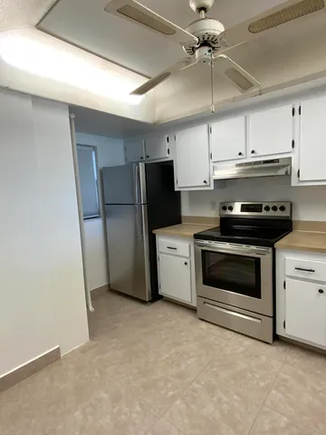 a kitchen with a refrigerator stove and white cabinets