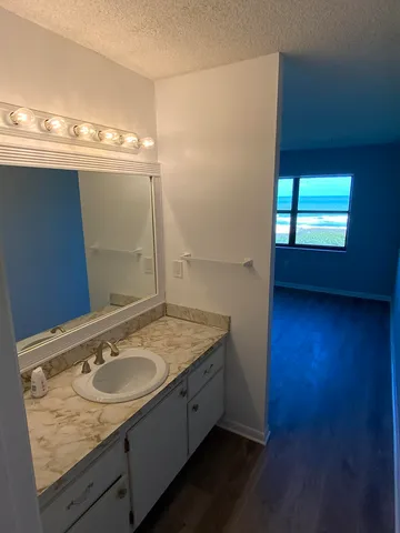 a bathroom with a granite countertop sink and a mirror