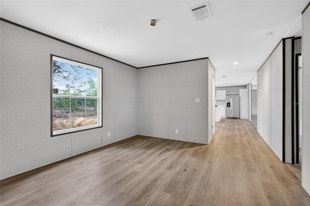 419 Lily Trail Interlachen, FL 32148 - Photo 28 of 78 a view of an empty room with wooden floor and a window