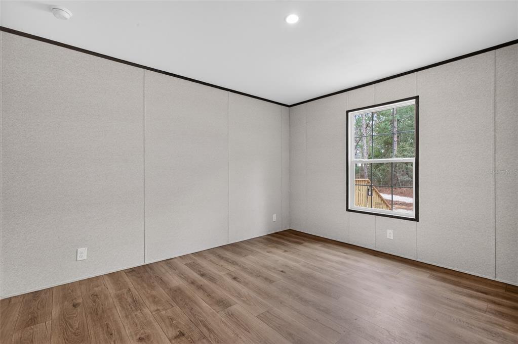 419 Lily Trail Interlachen, FL 32148 - Photo 30 of 82 an empty room with wooden floor and windows