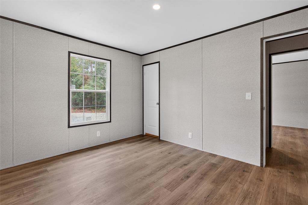 419 Lily Trail Interlachen, FL 32148 - Photo 35 of 78 an empty room with wooden floor and windows