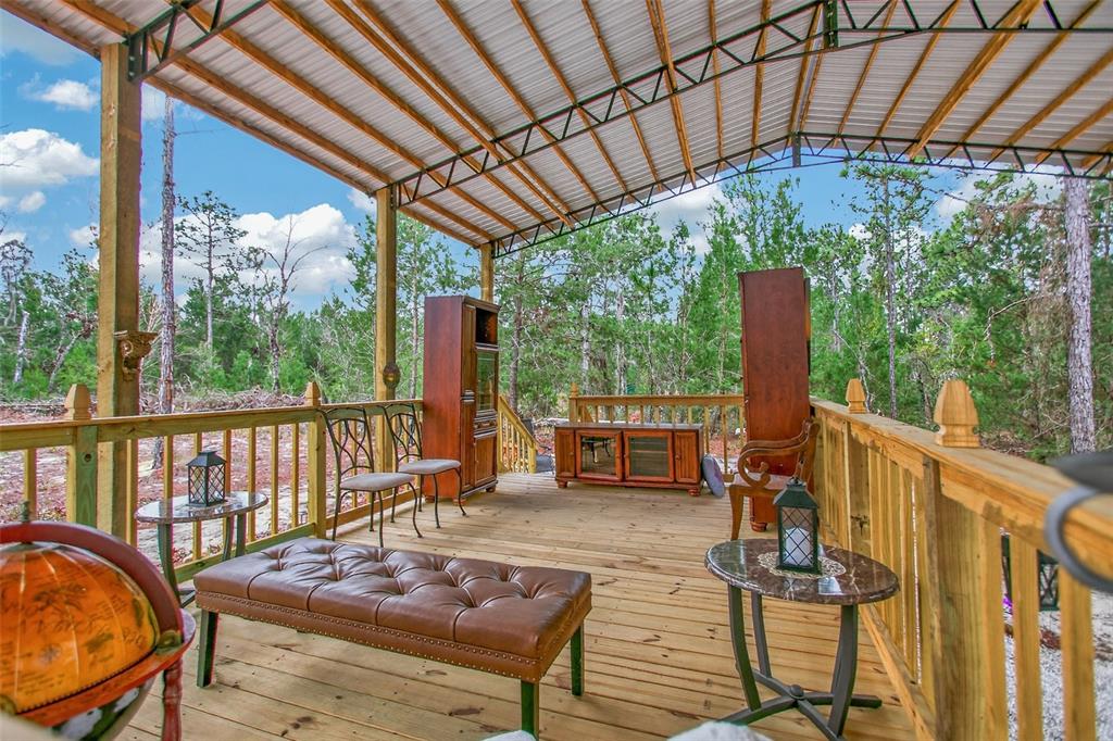 419 Lily Trail Interlachen, FL 32148 - Photo 48 of 78 a view of a patio with table and chairs potted plants with wooden floor and fence