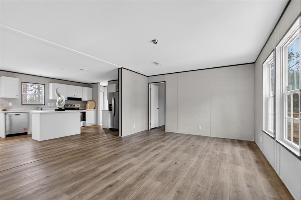 419 Lily Trail Interlachen, FL 32148 - Photo 7 of 78 a view of kitchen with refrigerator microwave and wooden floor