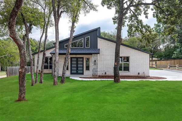 a view of a house with a yard and tree s
