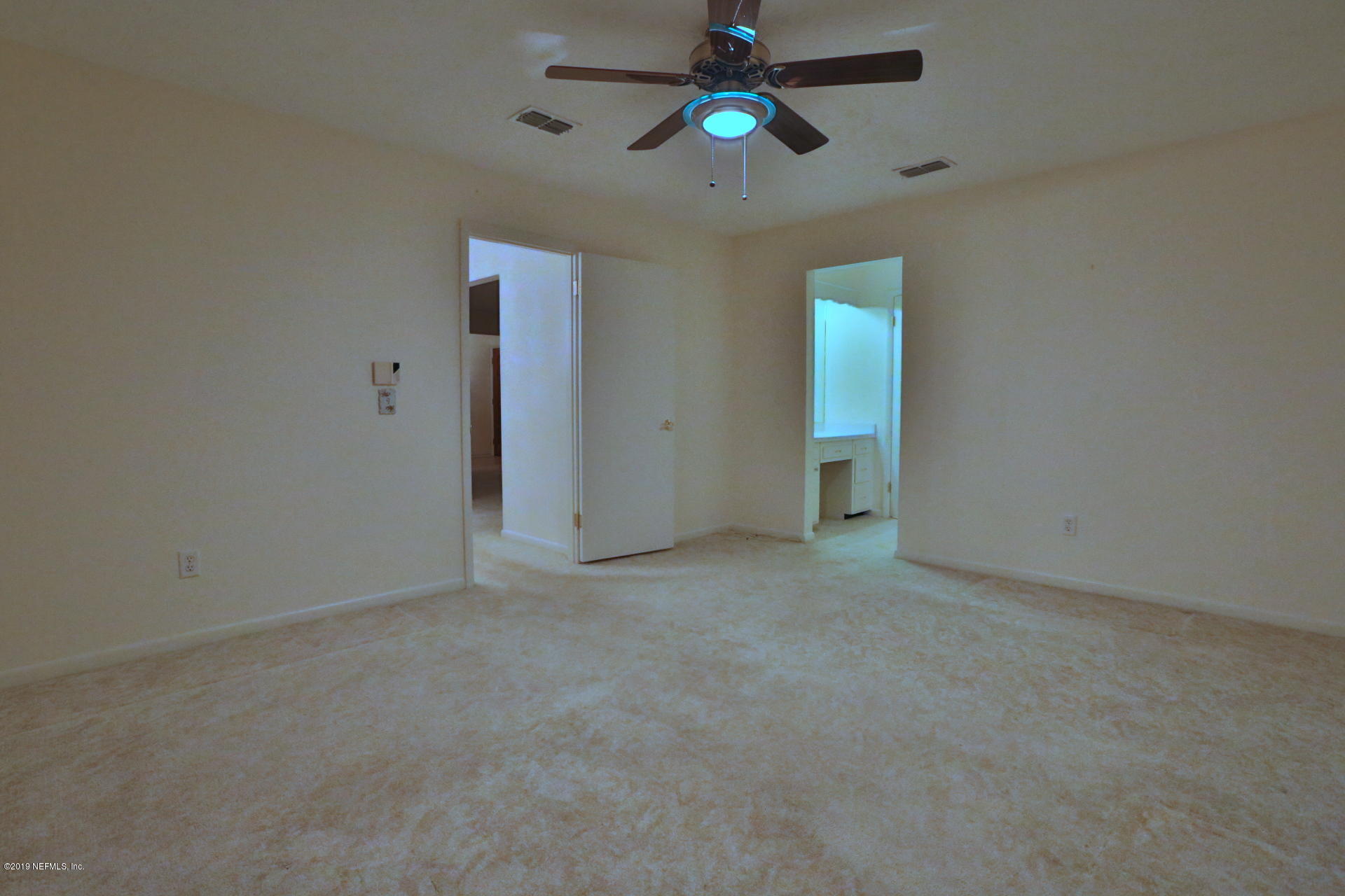 7305 Floral Ridge Drive Jacksonville, FL 32277 - Photo 16 of 27 an empty room with chandelier fan and windows
