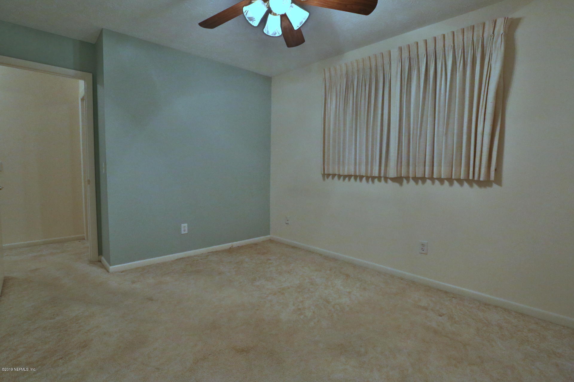 7305 Floral Ridge Drive Jacksonville, FL 32277 - Photo 25 of 27 an empty room with a ceiling fan and window