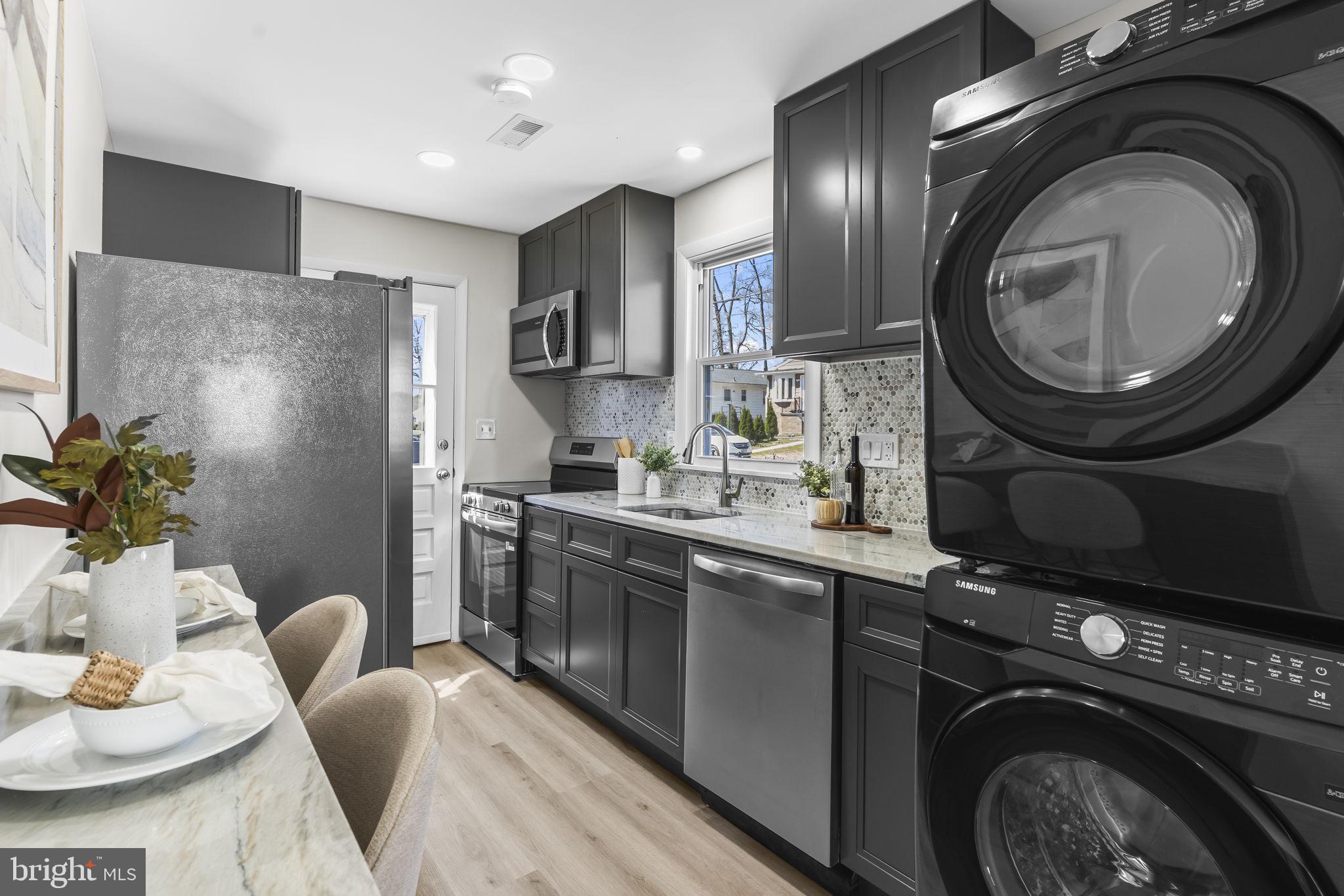 1923 Ridgeville Road Edgewater, MD 21037 - Photo 5 of 15 a kitchen with stainless steel appliances granite countertop a sink a washer and dryer