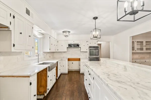 a large kitchen with stainless steel appliances kitchen island granite countertop a sink and cabinets