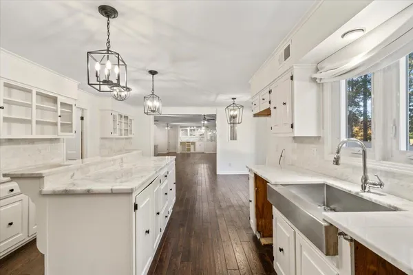 a very nice looking kitchen with granite countertop a sink stove and cabinets