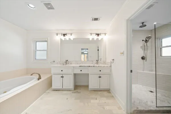 a spacious bathroom with a granite countertop tub sink shower and mirror