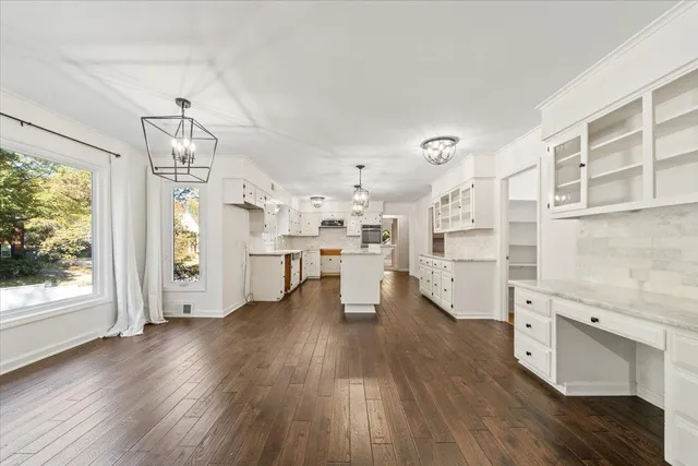 a large white kitchen with cabinets a sink and stainless steel appliances