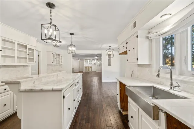 a very nice looking kitchen with granite countertop a sink stove and cabinets