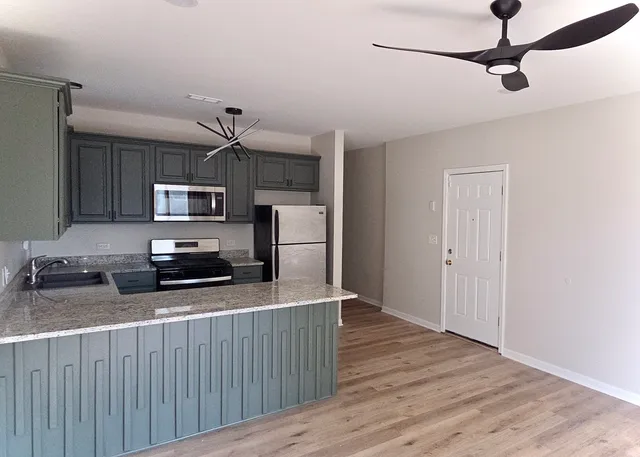 a kitchen with stainless steel appliances a refrigerator and a stove top oven