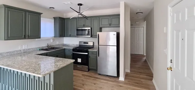 a kitchen with kitchen island a counter top space stainless steel appliances and cabinets