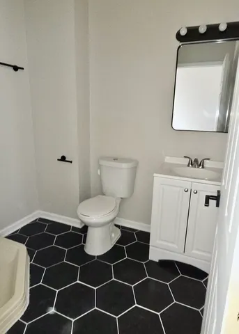 a bathroom with a sink toilet and a mirror